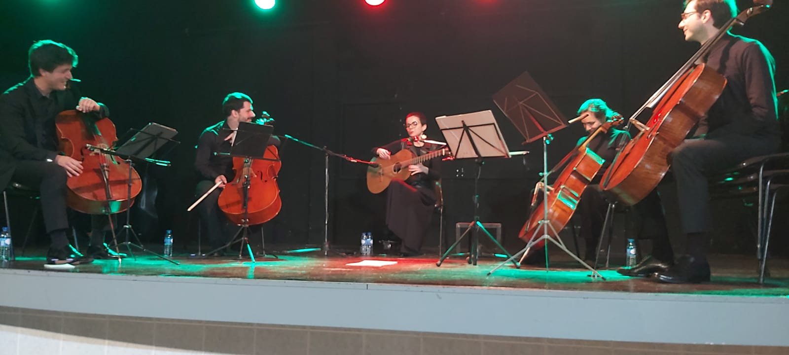 Quinteto de cordas em palco sob iluminação cénica verde e vermelha